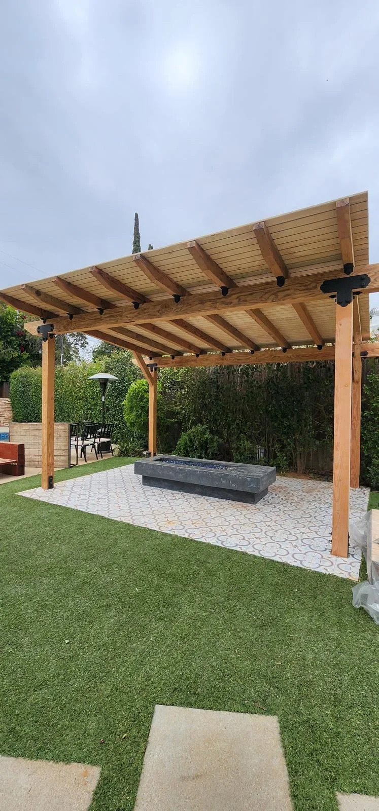 Cedar pergola with slat roof over patterned paver patio and fire pit in Cape Coral backyard
