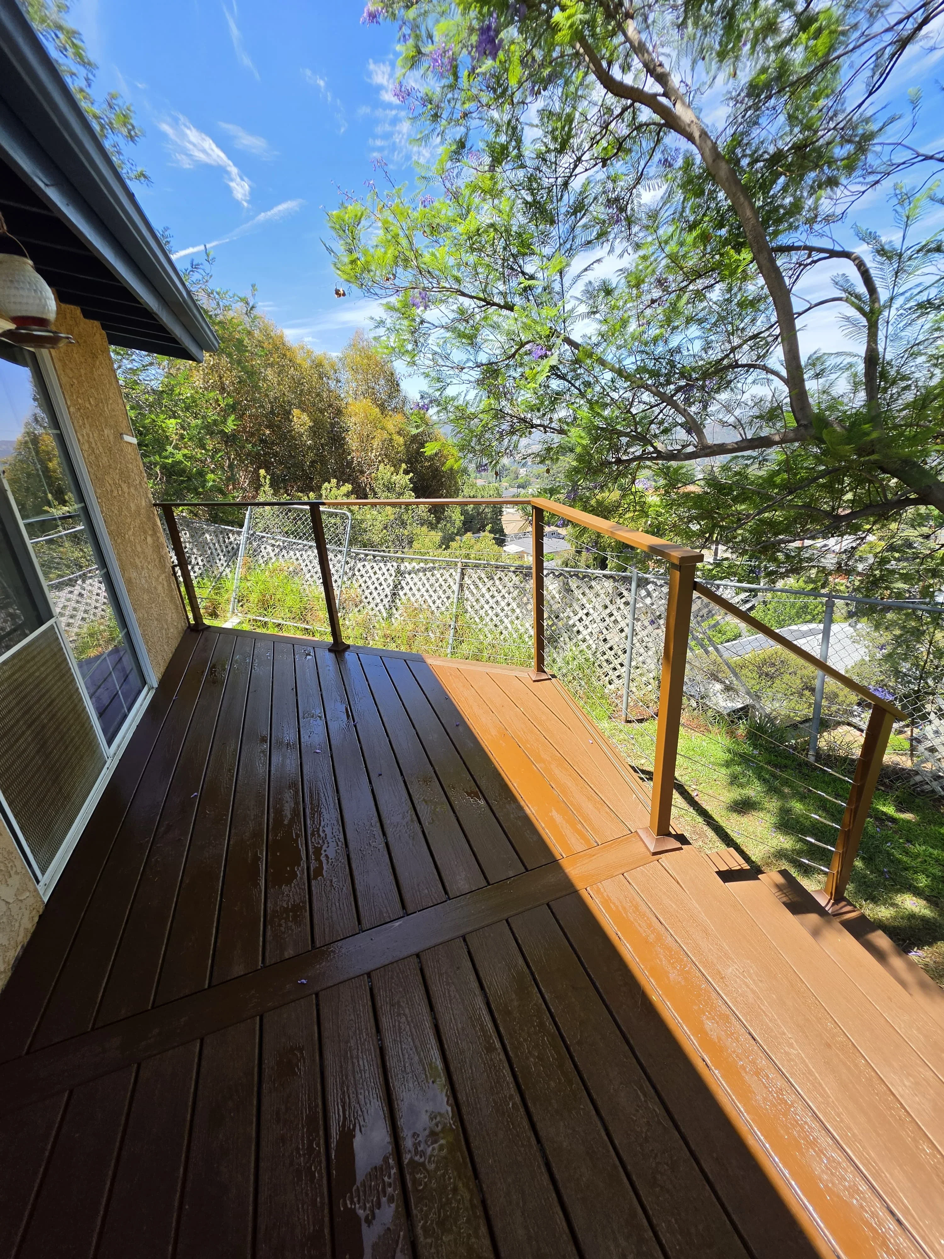 Elevated composite deck with cable railings overlooking wooded landscape in Cape Coral