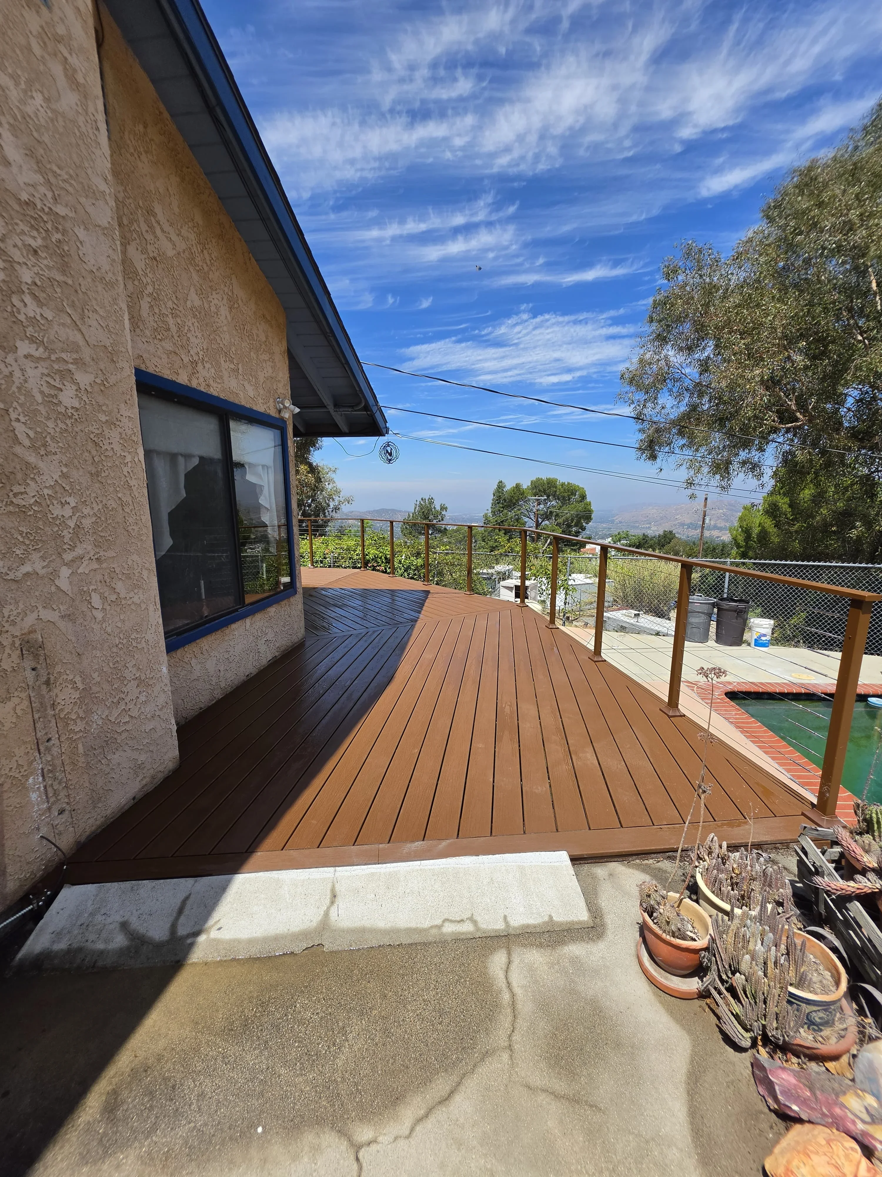 Composite deck with metal railings overlooking valley landscape